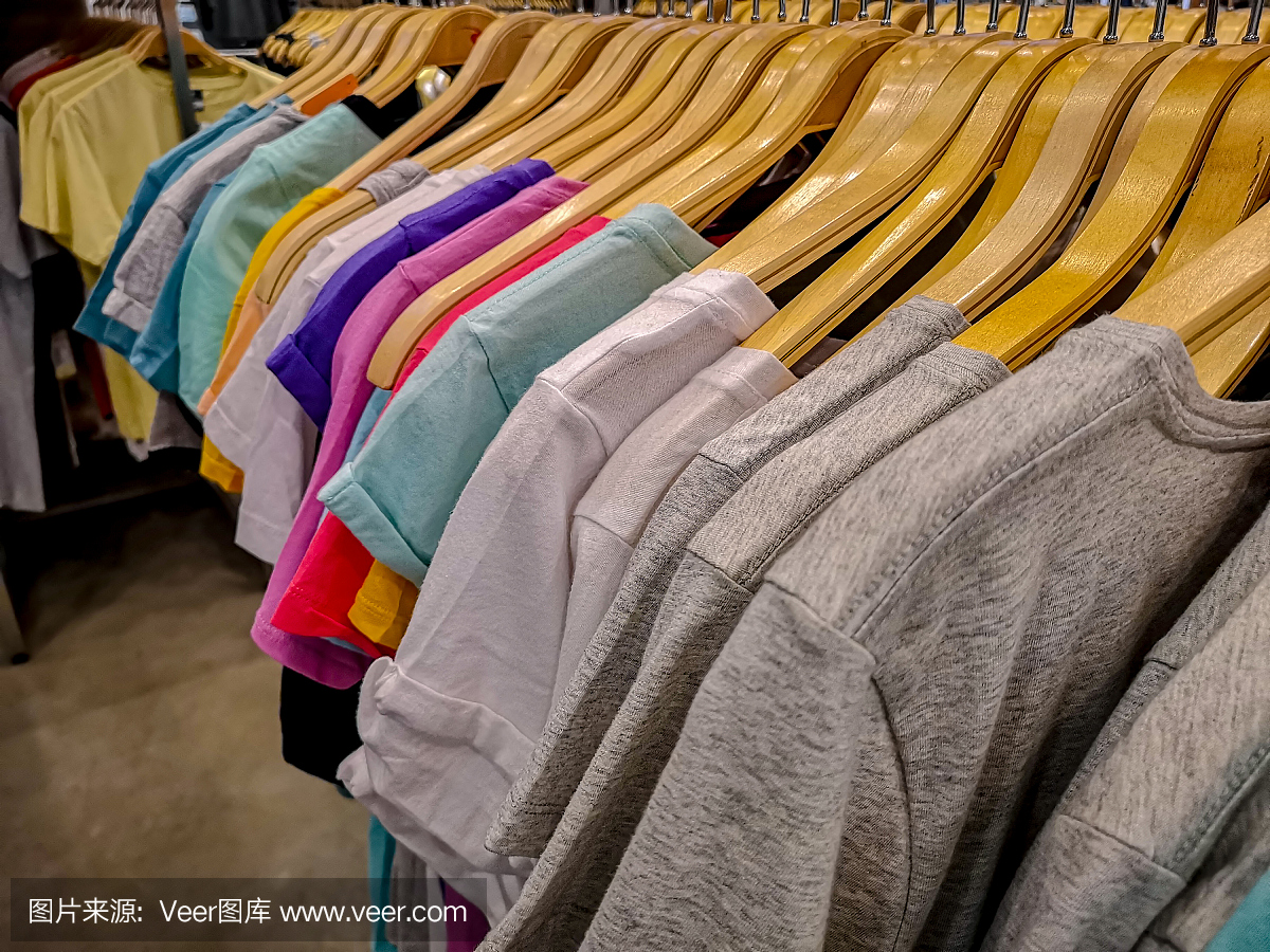 在一家高街的女装商店里,一排排五颜六色的t恤挂在衣架上出售。